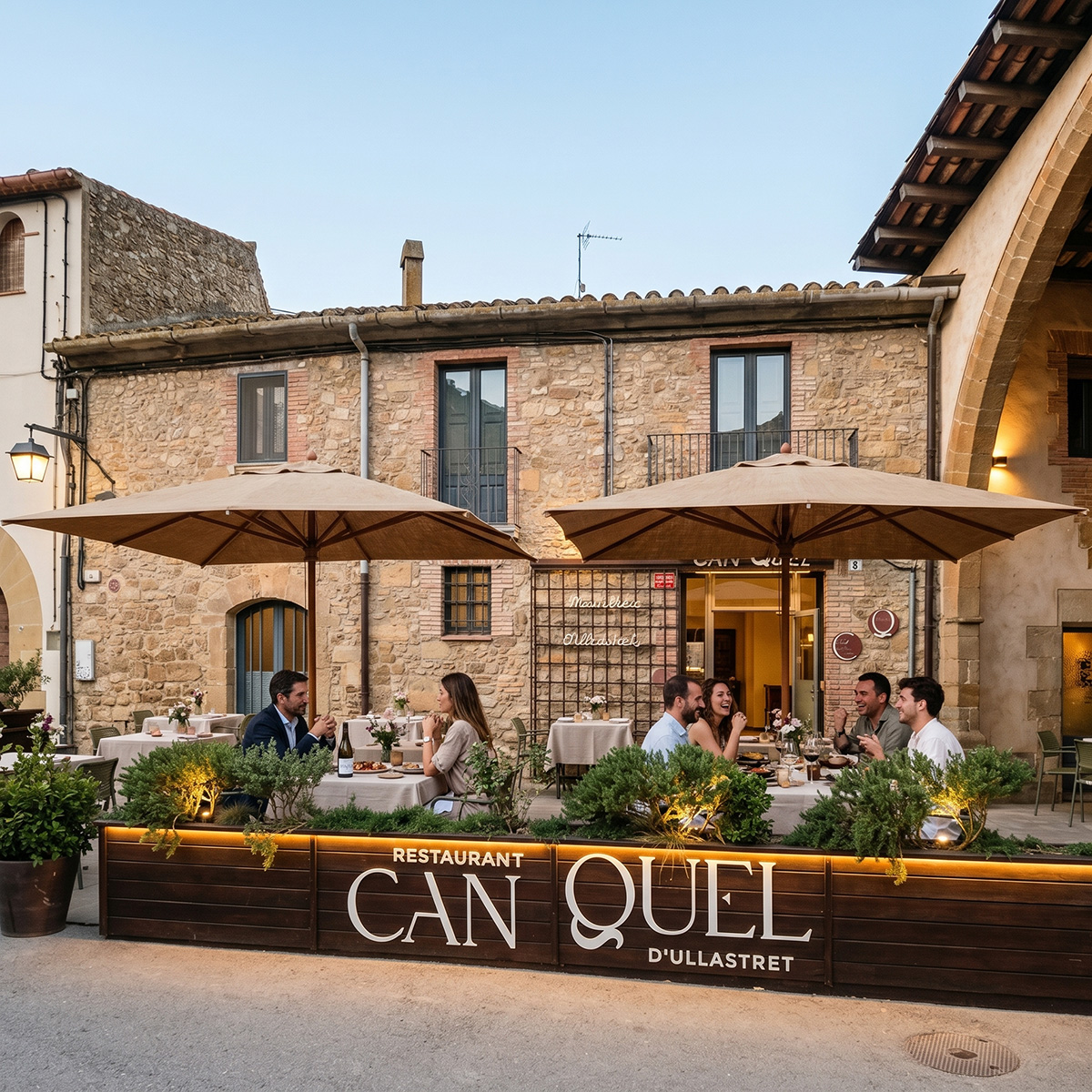 Façana i terrassa del Restaurant Can Quel d'Ullastret amb comensals sopant